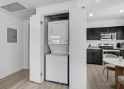 Thumbnail 13 of 22 - a white washer and dryer unit in a room with a dining room table