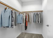 Thumbnail 15 of 22 - a closet with a row of clothes hanging on a rack
