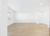 Thumbnail 20 of 33 - A room with wooden flooring and white walls.