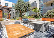Thumbnail 24 of 35 - A patio with a table, chairs, and a grill.