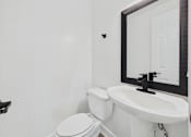 Thumbnail 12 of 12 - A white toilet and sink in a bathroom.