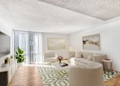 Thumbnail 3 of 17 - A living room with a white couch, a green and white rug, and a painting on the wall.