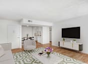 Thumbnail 2 of 17 - A living room with a white couch, a white chair, a white coffee table, a white cabinet, a white TV, a white rug, and a white wall.