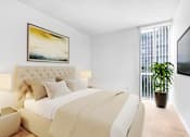 Thumbnail 5 of 17 - A bedroom with a large bed and a painting on the wall.