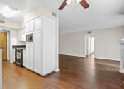 Thumbnail 2 of 15 - an empty living room with white cabinets and a wood floor