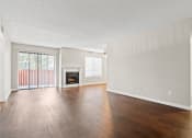 Thumbnail 3 of 15 - the spacious living room with wood flooring and a fireplace