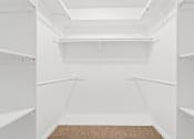 Thumbnail 8 of 15 - a walk in closet with white walls and white shelves
