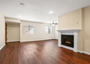 Thumbnail 12 of 15 - an empty living room with a fireplace and wooden floors