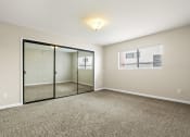 Thumbnail 14 of 15 - an empty living room with mirrored doors and carpeting