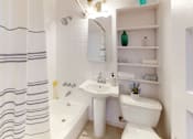 Thumbnail 21 of 21 - A white bathroom with a white toilet, sink, and bathtub.