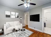 Thumbnail 3 of 21 - A living room with a white couch and a black and white rug.