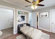 Thumbnail 14 of 21 - A living room with a couch and a ceiling fan.