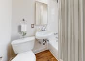 Thumbnail 5 of 21 - A white toilet sits next to a sink in a bathroom.