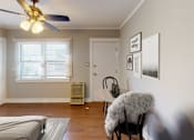 Thumbnail 15 of 21 - A room with a bed, a chair, a fan, and pictures on the wall.