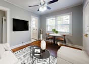 Thumbnail 2 of 21 - A living room with a white couch and a black and white rug.