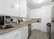 Thumbnail 1 of 49 - a kitchen with white cabinets and granite counter tops and stainless steel appliances