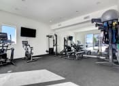 Thumbnail 7 of 75 - a spacious fitness room with cardio equipment and a flat screen tv