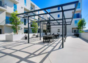 Thumbnail 4 of 75 - a patio with tables and chairs in front of an apartment building