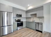 Thumbnail 56 of 75 - a kitchen with gray cabinets and stainless steel appliances