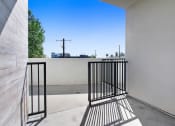 Thumbnail 58 of 75 - a balcony with a black gate and a tree in the background