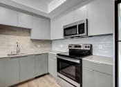 Thumbnail 9 of 75 - a kitchen with gray cabinets and stainless steel appliances