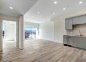 Thumbnail 42 of 75 - a kitchen and living room with white walls and hardwood floors