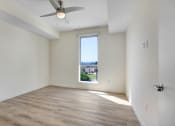 Thumbnail 48 of 75 - a bedroom with a large window and hardwood floors