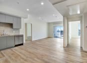 Thumbnail 22 of 75 - an empty living room with a kitchen and a balcony