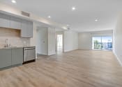 Thumbnail 72 of 75 - an empty living room with a kitchen and a balcony