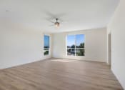 Thumbnail 74 of 75 - an empty living room with a large window and a ceiling fan