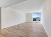 Thumbnail 51 of 75 - a bedroom with hardwood floors and a large window