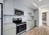 Thumbnail 49 of 75 - a kitchen with white cabinetry and stainless steel appliances