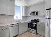Thumbnail 31 of 75 - a kitchen with gray cabinets and stainless steel appliances