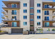 Thumbnail 17 of 20 - Apartment building with balconies and a garage door.