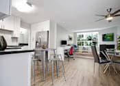 Thumbnail 35 of 76 - Dining area with ceiling fan, cozy fireplace in the den and living room, wood-like floors throughout