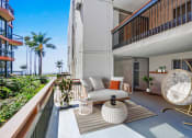 Thumbnail 4 of 86 - a living room with a couch and a table on a balcony