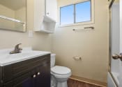 Thumbnail 24 of 48 - Bathroom with shower and tub combo at the right, single vanity with dark brown wood style cabinet