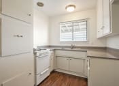 Thumbnail 20 of 48 - Kitchen with white gas stove, granite countertops, White kitchen cabinets