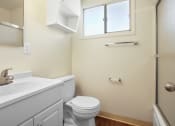 Thumbnail 21 of 48 - Bathroom with shower and tub combo at the right, single vanity with white cabinet