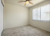 Thumbnail 16 of 48 - Bedroom with sliding closet door at the left, ceiling fan, carpeted flooring