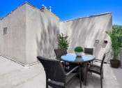 Thumbnail 18 of 39 - a patio with a table and chairs and a wall with a door