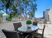 Thumbnail 17 of 39 - a patio with a table and chairs and trees in the background