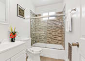 Thumbnail 16 of 31 - a bathroom with a white sink and toilet and a shower with a glass door