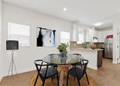 Thumbnail 7 of 32 - a dining area with a glass table and chairs and a kitchen in the background