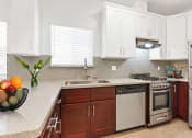 Thumbnail 5 of 32 - a kitchen with white cabinets and a bowl of fruit on the counter