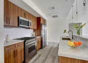 Thumbnail 17 of 26 - a kitchen with wooden cabinets and white countertops