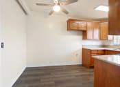 Thumbnail 8 of 48 - a kitchen with wood cabinets and a ceiling fan