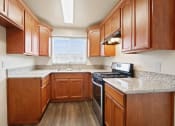 Thumbnail 6 of 48 - a kitchen with wood cabinets and granite countertops