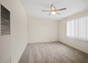 Thumbnail 11 of 48 - a bedroom with white walls and a white ceiling fan