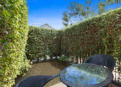 Thumbnail 16 of 61 - a patio with a table and chairs and a hedge